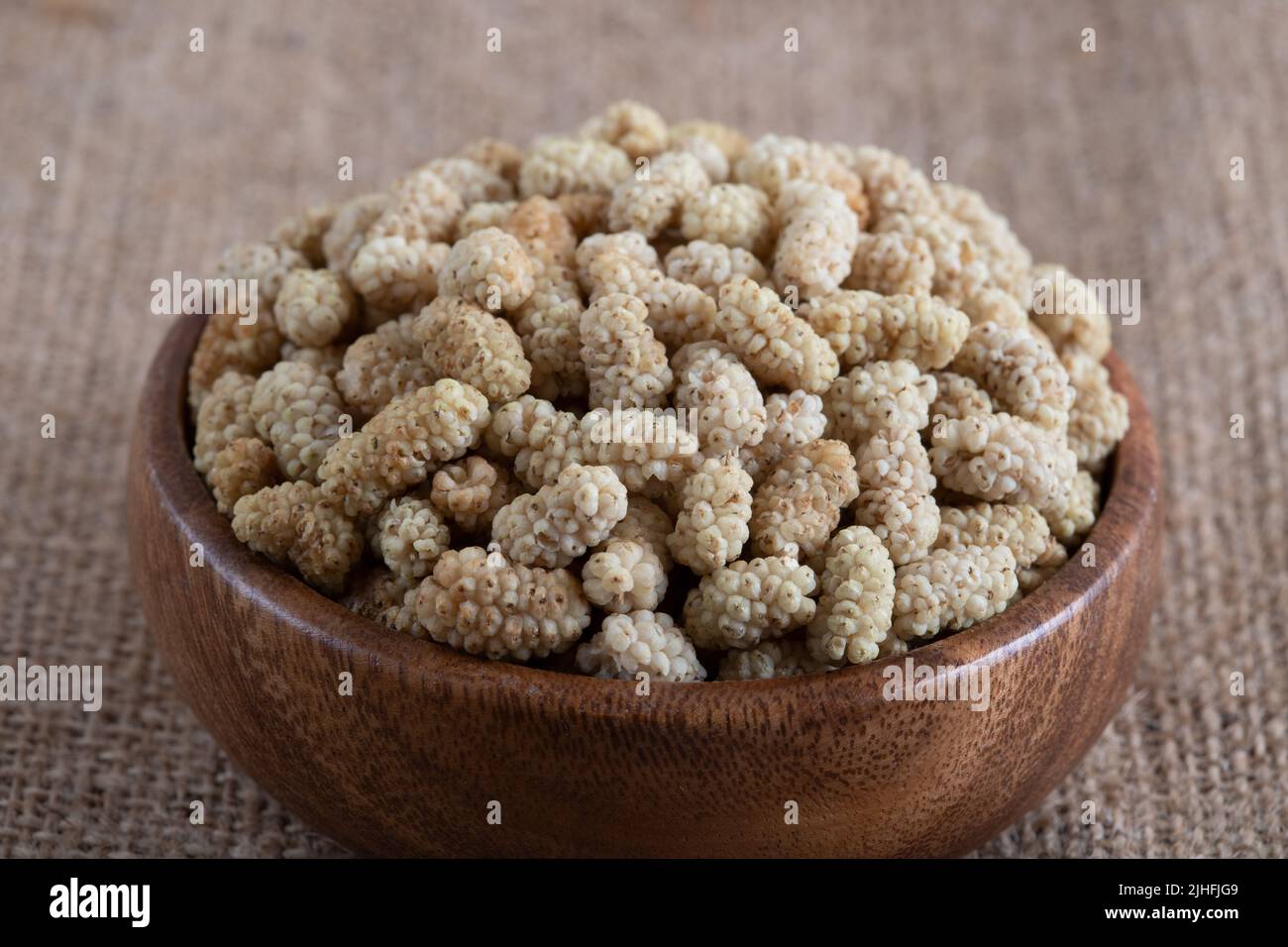 Ciotola piena di gelso secco su uno sfondo di tessuto Foto Stock