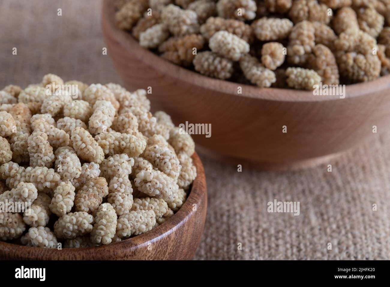 Ciotola piena di gelso secco su uno sfondo di tessuto Foto Stock