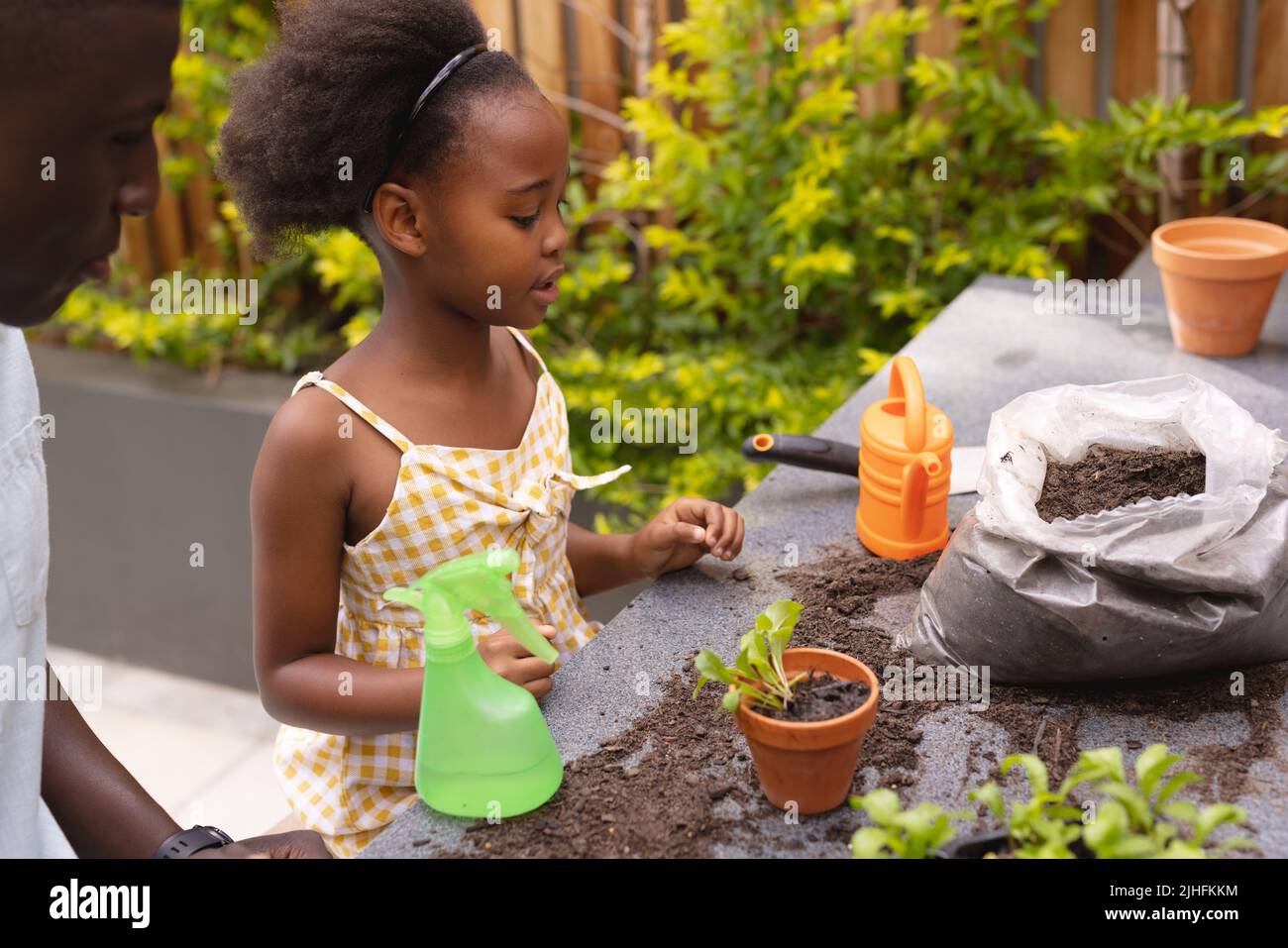 Immagine di felice afroamericana figlia e padre giardinaggio Foto Stock