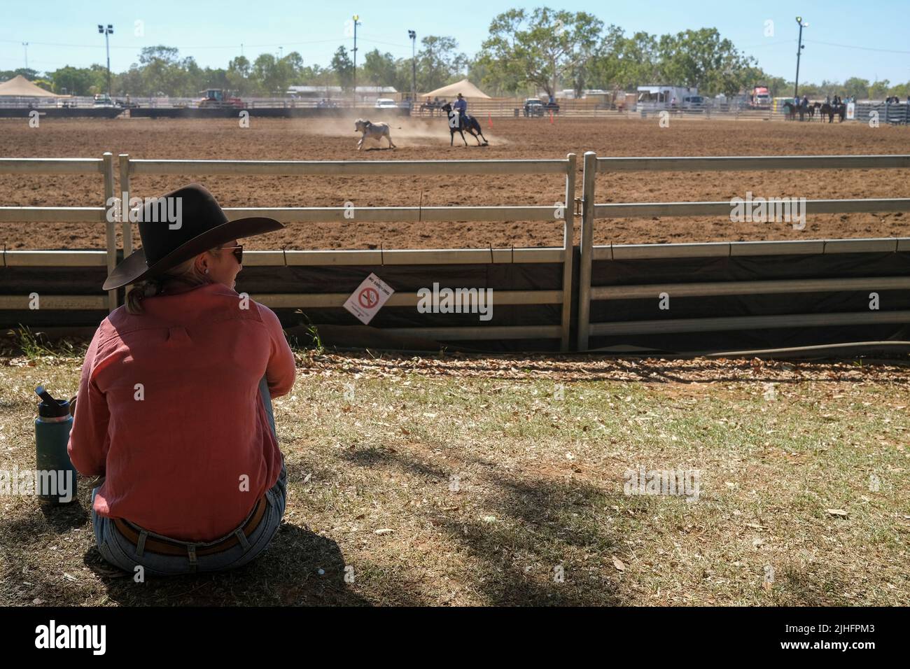 Una donna guarda il rodeo del lavoro del bestiame al Katherine Show di Katherine, Northern Territory, Australia. Foto Stock