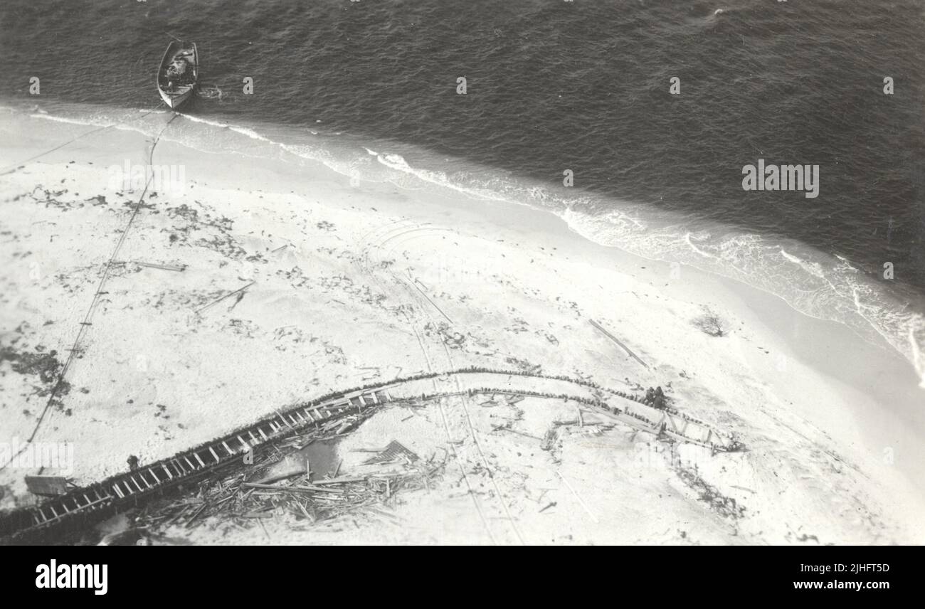 New Jersey - Barnegat. Guardando verso il basso dalla galleria della sala d'osservazione nella parte esterna del molo ovest - la metà esterna levigata fino alla cima delle pile. Annotare le tracce del carro. Il lancio è quello del contraente e sta pompando acqua a getti pile all'estremità interna del molo. Foto Stock