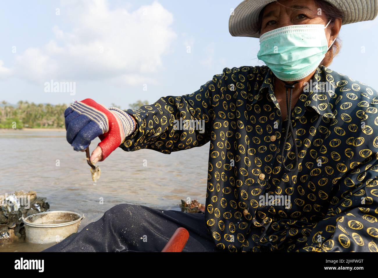 Ko Phangan, Thailandia, 15 marzo 2022: Donna anziana che lavora sul mare per sopravvivere Foto Stock