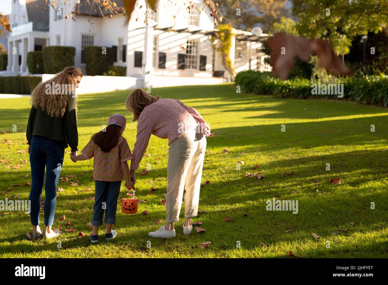 Immagine di nonna caucasica, madre e figlia in costume da Halloween nel giardino d'autunno Foto Stock