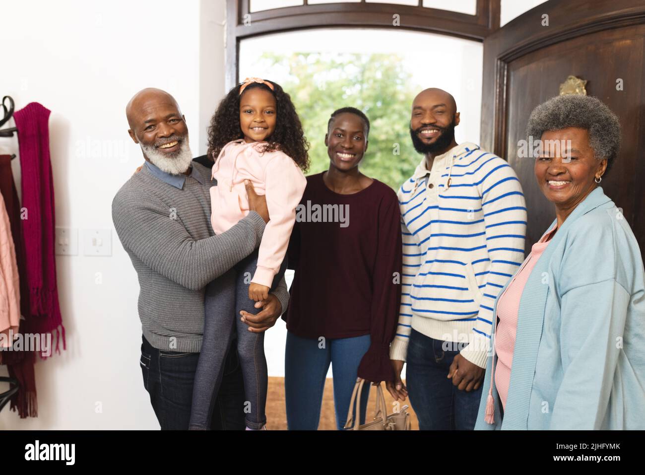 Immagine di allegro afroamericano di più generazioni che posa in porta Foto Stock