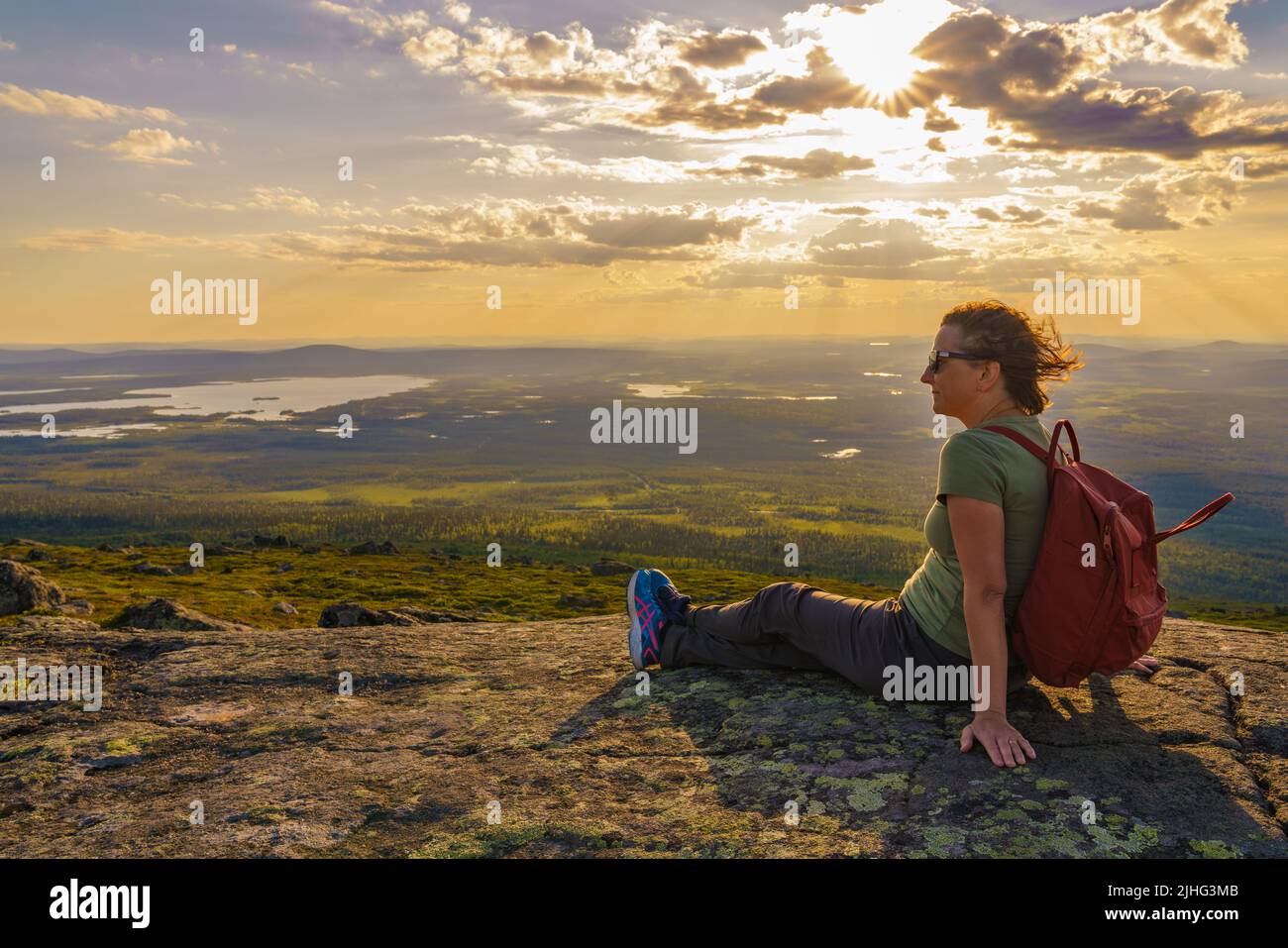 Donna seduta in montagna godendo la vista dal Monte Dundret su Laponia, contea di Gällivare, Lapponia svedese, Svezia Foto Stock