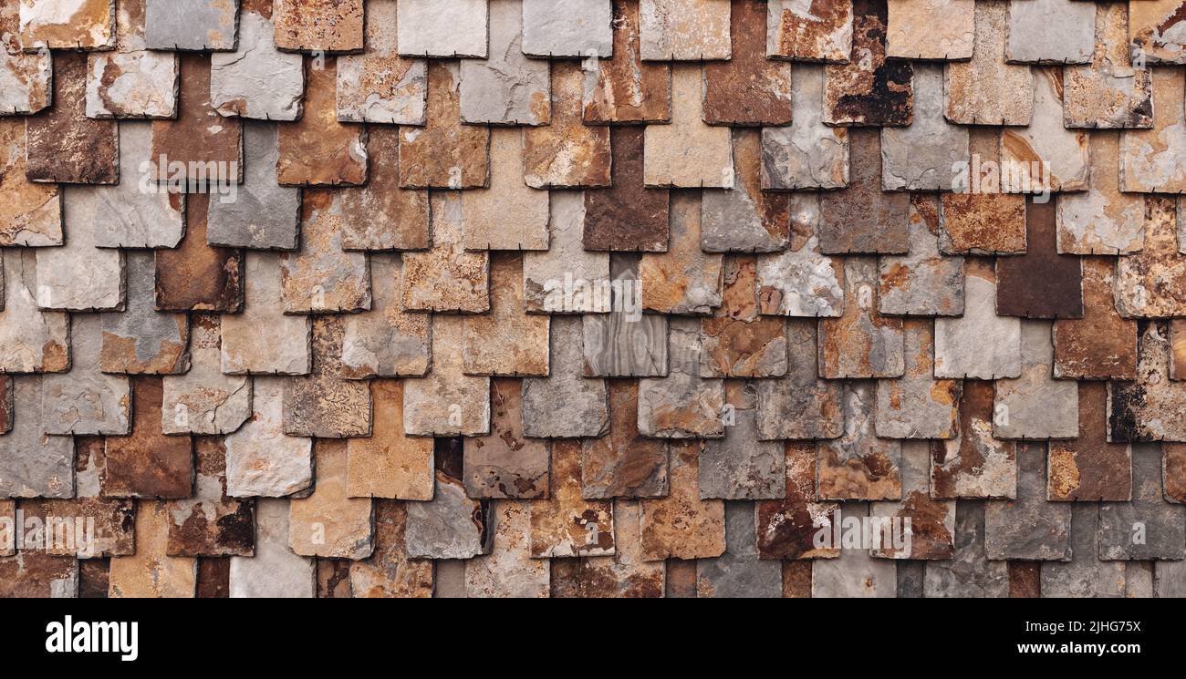 muro di ardesia marrone ruggine, muro di mattoni in pietra naturale, sfondo di mattonelle in ardesia Foto Stock