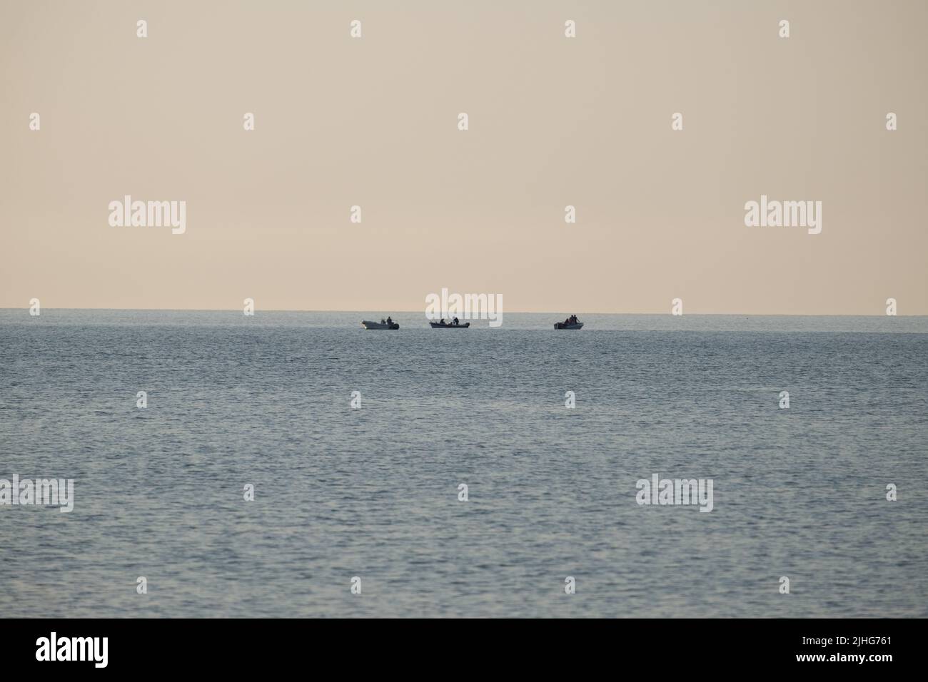 Barche da pesca che pescano nelle calme acque del mattino del mar Egeo Foto Stock