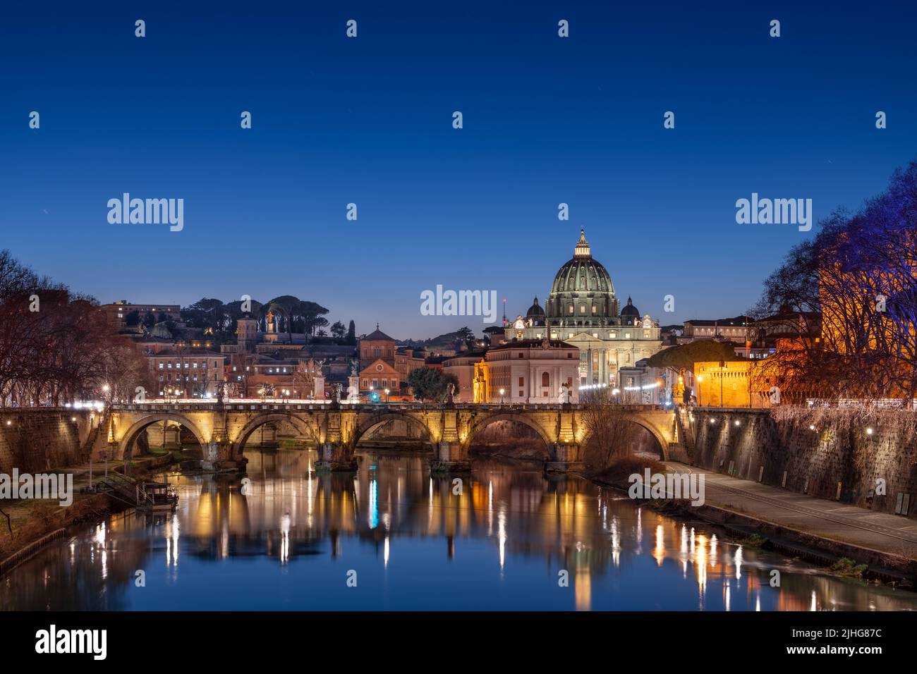 Basilica di San Pietro a Città del Vaticano sul Tevere attraverso Roma, Italia al crepuscolo. Foto Stock