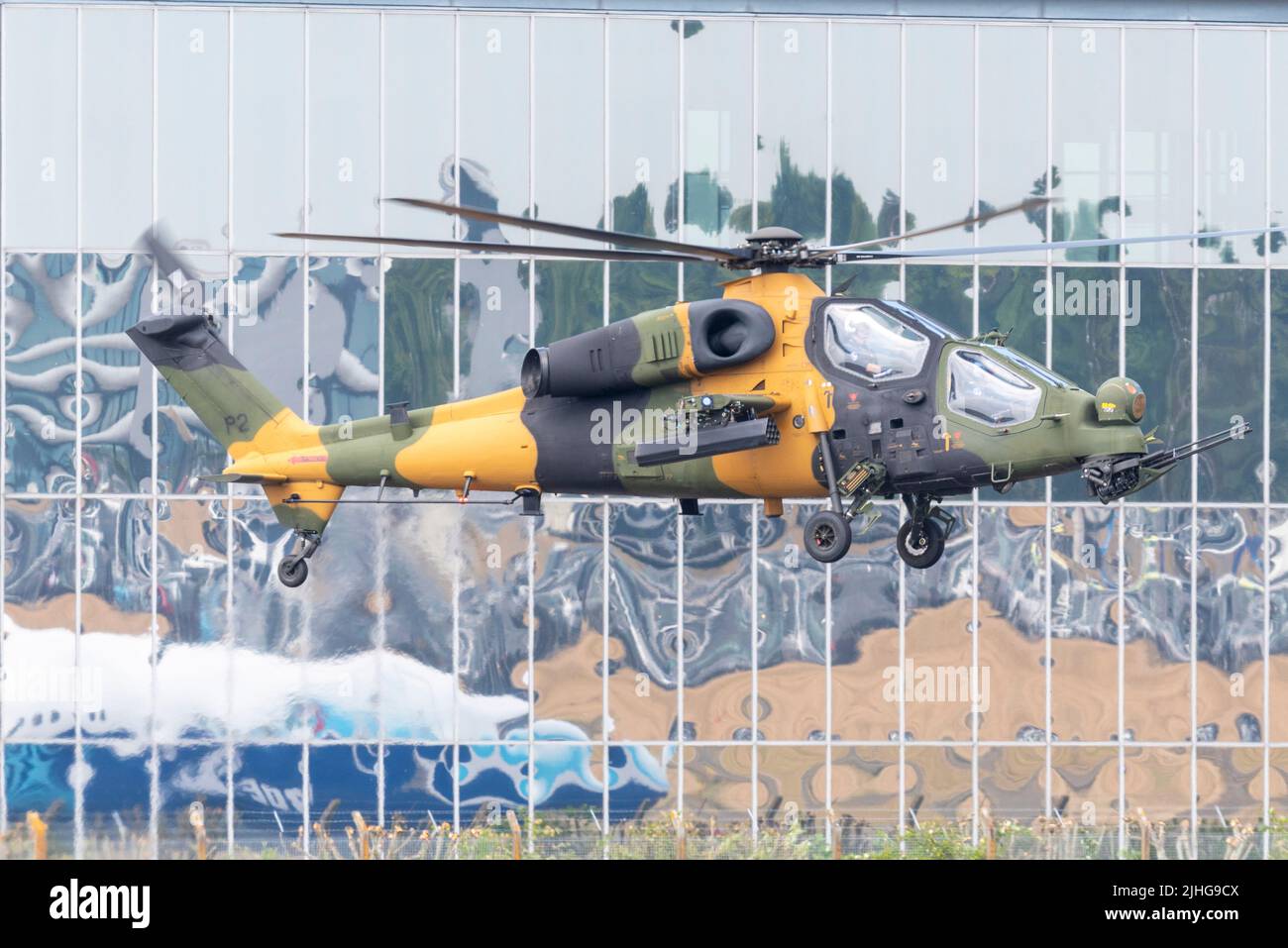 Farnborough, Hampshire, Regno Unito. 18th Lug 2022. La fiera delle tecnologie aerospaziali civili e militari è tornata dopo la rottura dovuta alla pandemia conviviale con le principali aziende mondiali di aviazione e tecnologia spaziale che espongono i loro prodotti in aria e sul terreno. Le sale di commercio sono occupate con la gente di affari che fa i contatti. Turkish Aerospace Industries/ AgustaWestland T129 elicottero militare ATAK con dietro l'edificio Farnborough. Un elicottero da attacco a motore doppio, tandem, multi-ruolo e per tutte le condizioni meteorologiche. Foto Stock