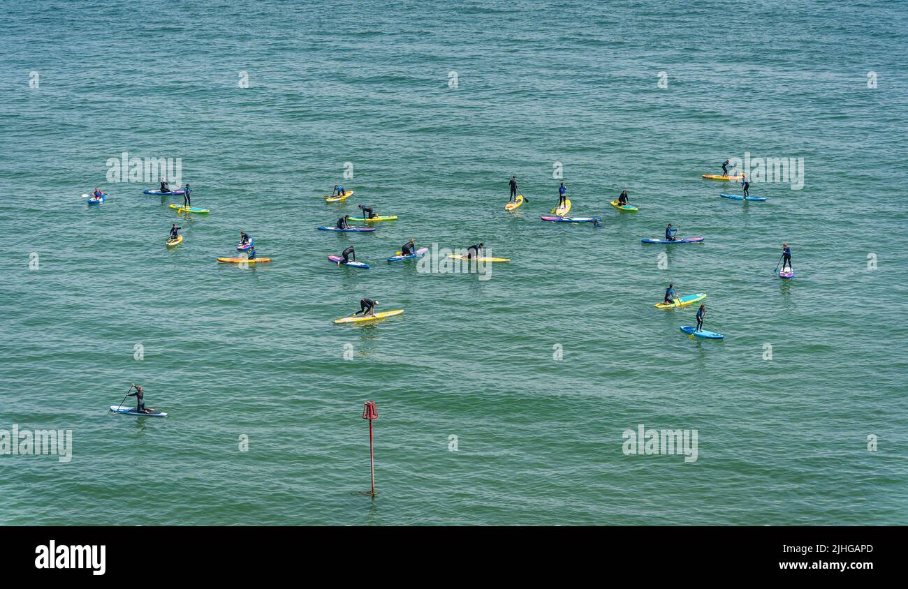 Tenby, Galles - Maggio 2021 : nuotatori Paddle boarding in una giornata calda a Tenby Coast , Carmarthen Bay, Pembrokeshire Foto Stock