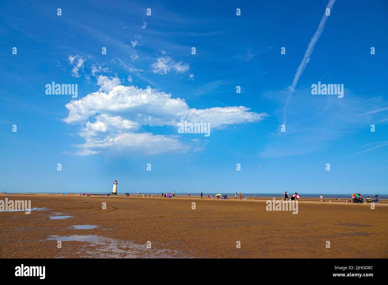 La giornata più calda mai nel Regno Unito a Talacre Beach, e il faro Point of Ayr, Flintshire, Galles del Nord Foto Stock