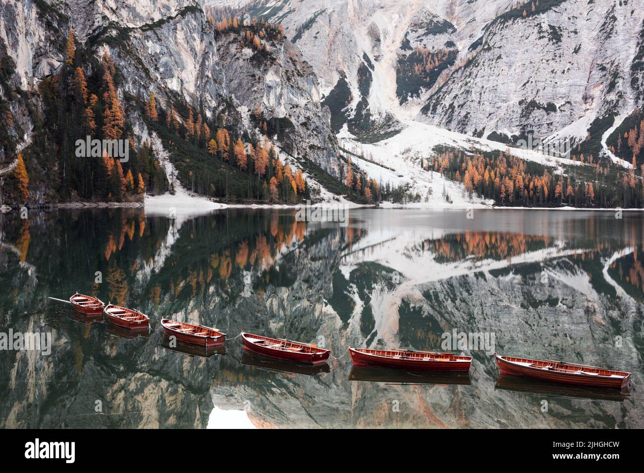 Paesaggio pittoresco con il famoso lago di Braies in autunno Dolomiti montagne. Barche in legno e molo nelle acque limpide del Lago di Braies, Alpi dolomitiche, Italia. Vetta del monte Seekofel sullo sfondo Foto Stock