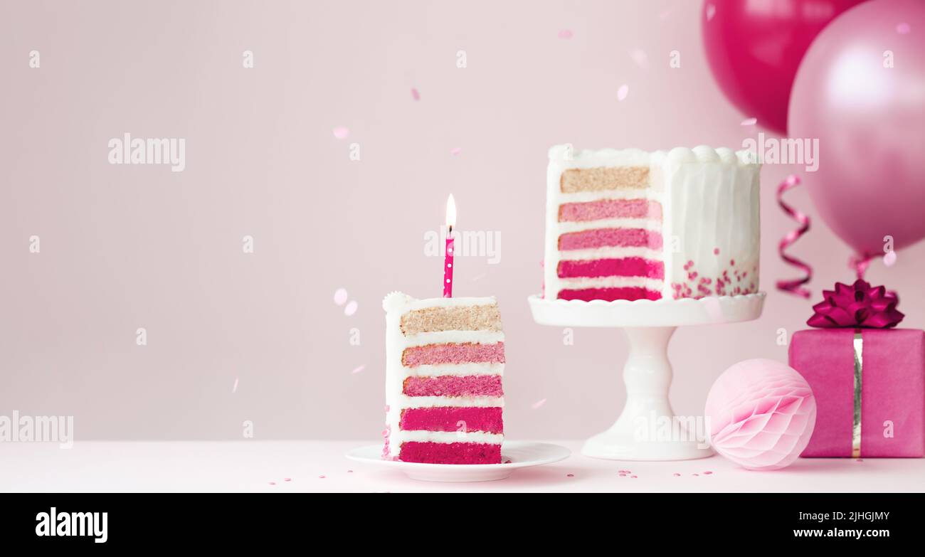 Torta di compleanno rosa ombre con palloncini e fetta di torta di compleanno e candela Foto Stock
