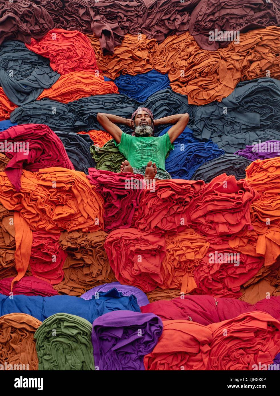 Le coperte colorate vengono caricate sui camion dai lavoratori. Industria tessile in Bangladesh Foto Stock