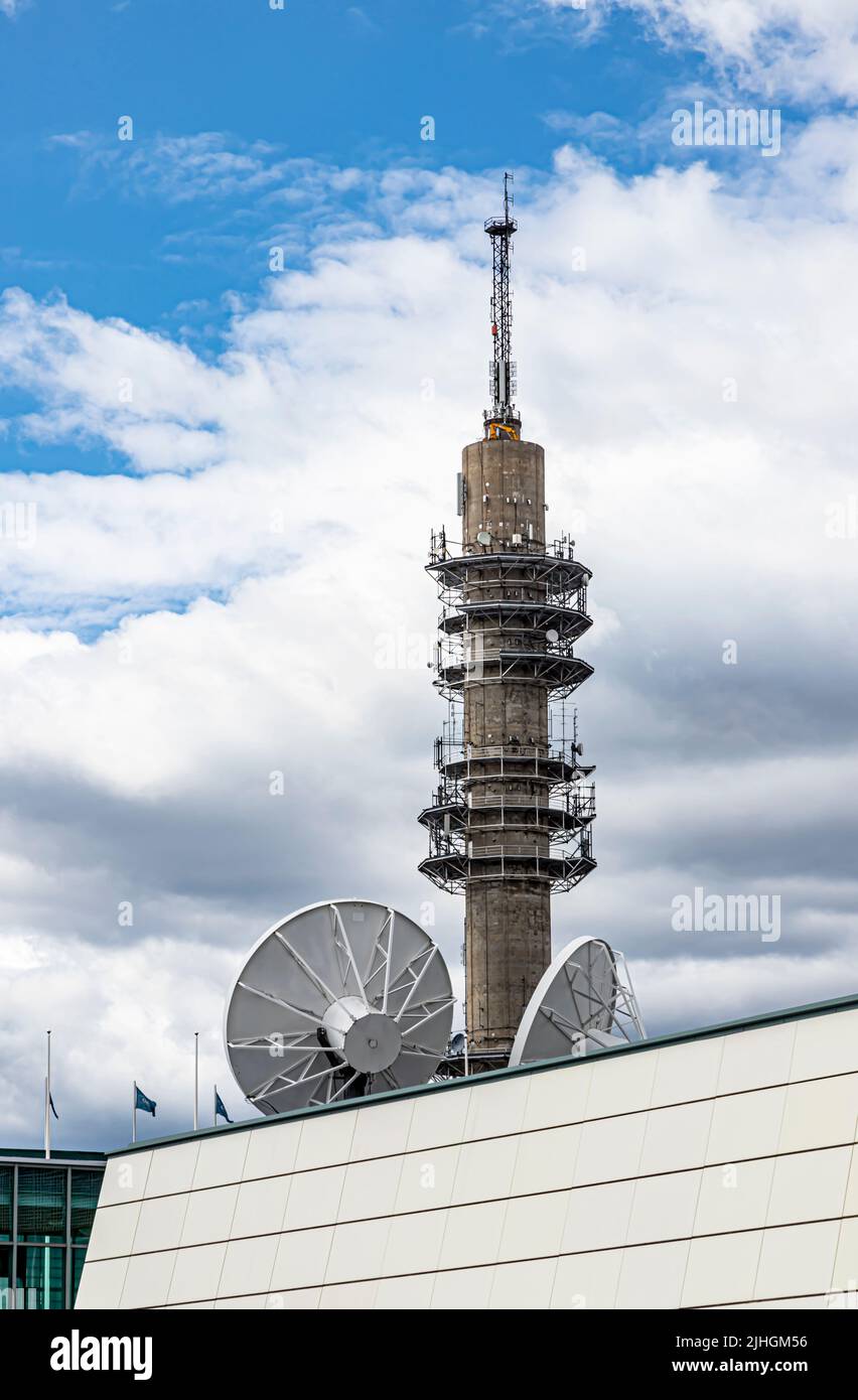 La torre di trasmissione YLE a Pasila, Helsinki, Finlandia. In primo piano, antenne paraboliche sul tetto dell'arena di Helsinki. Foto Stock