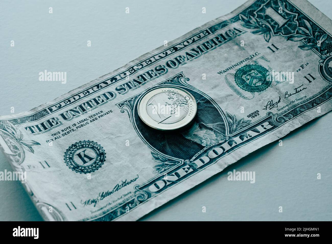 Una moneta da 1 euro su una fattura da 1 dollari americani, raffigurante la quasi parità tra le due valute Foto Stock