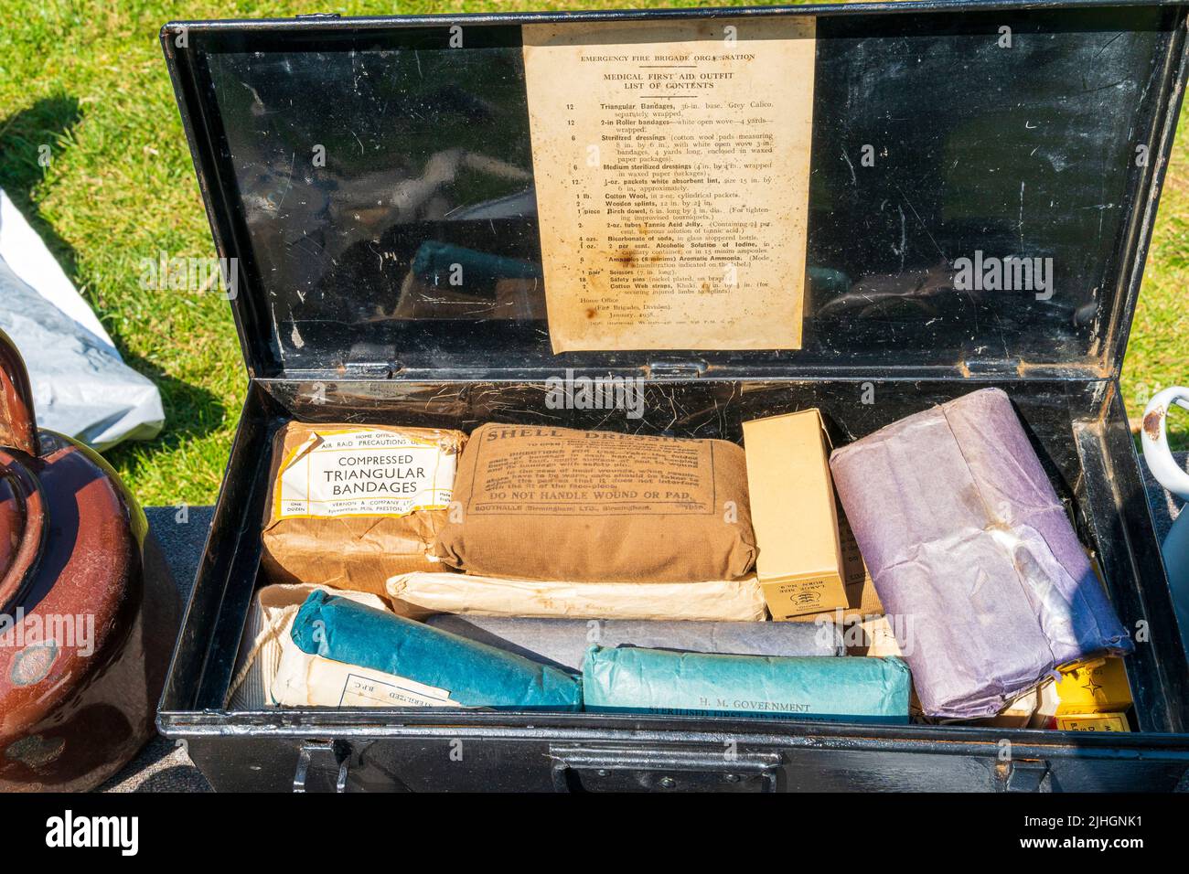 World War Two Emergency Fire Brigade scatola medica in metallo nero, aperta, con il contenuto di vari articoli confezionati come medicazioni e bende. Foto Stock