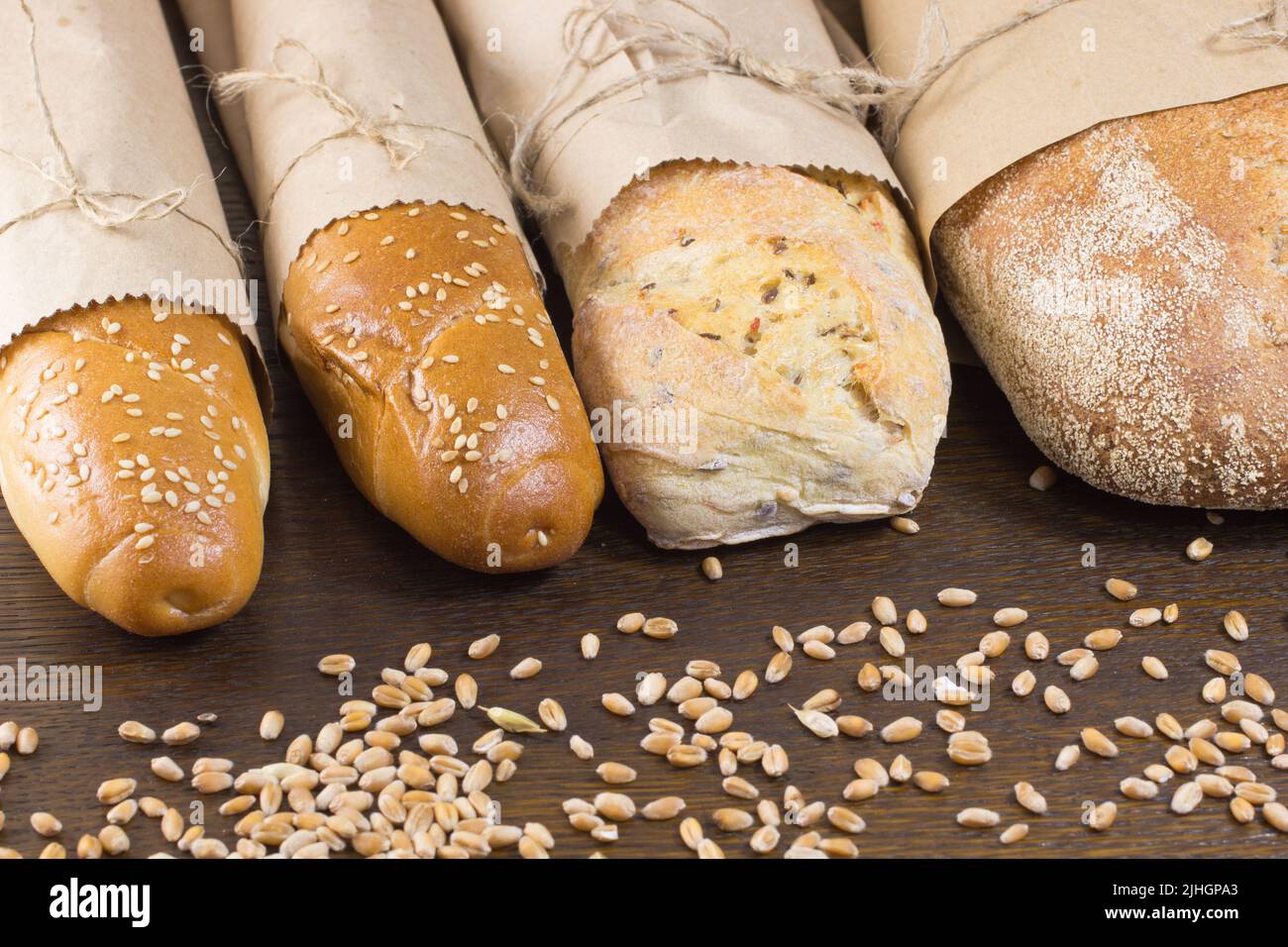 Quattro baguette e grano sul tavolo Foto Stock