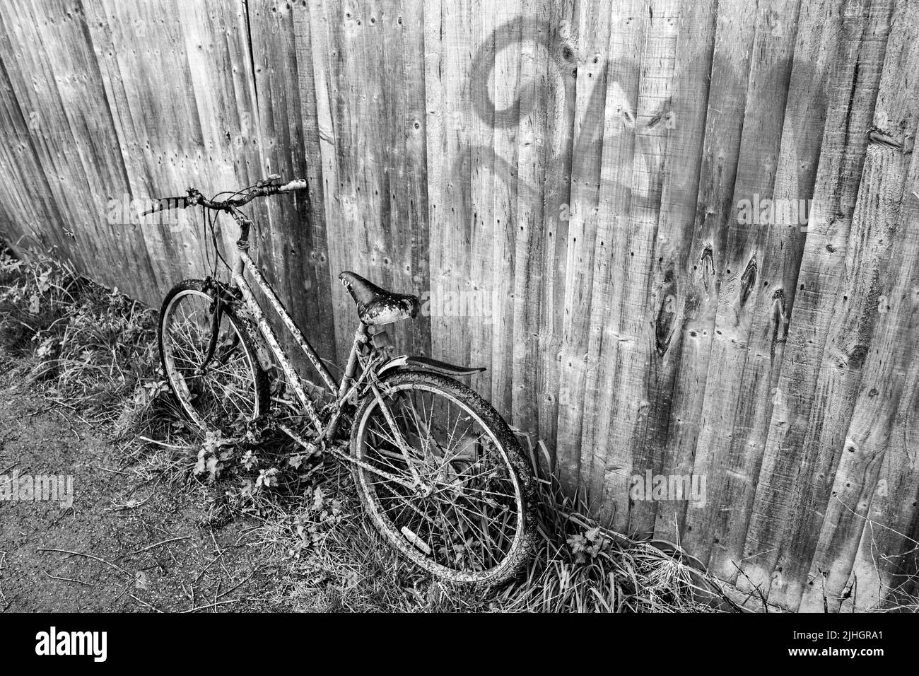 Una bicicletta abbandonata è rimasta su un sentiero a piedi in posizione verticale e si sporca ogni giorno. Foto Stock