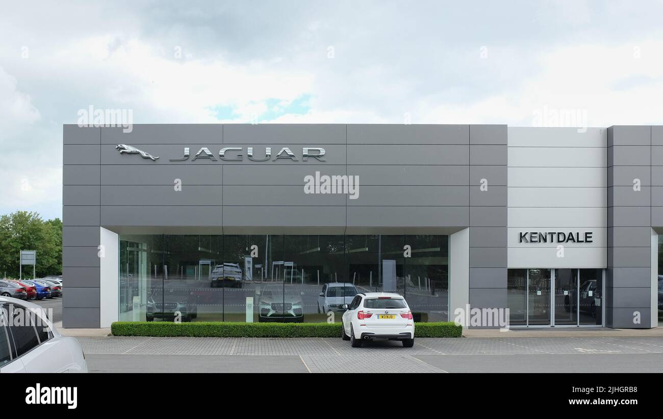 Garage Jaguar Land Rover Kentdale in Cumbria, Regno Unito, con il marchio e i loghi Jaguar esposti in modo preminente nel grande e moderno showroom della concessionaria. Foto Stock