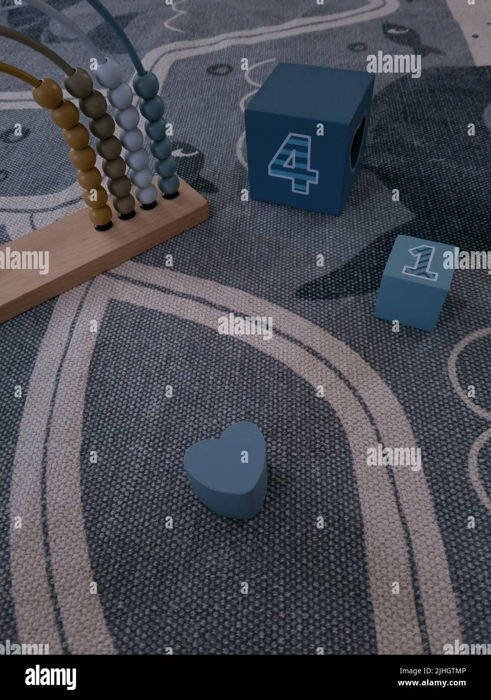 I bambini si bloccano e abacus su un tappeto. Giocattoli in legno moderni ed ecologici per un bambino. I giocattoli per l'istruzione si appoggiano su un tappeto. Imparare i numeri e contare. Foto Stock