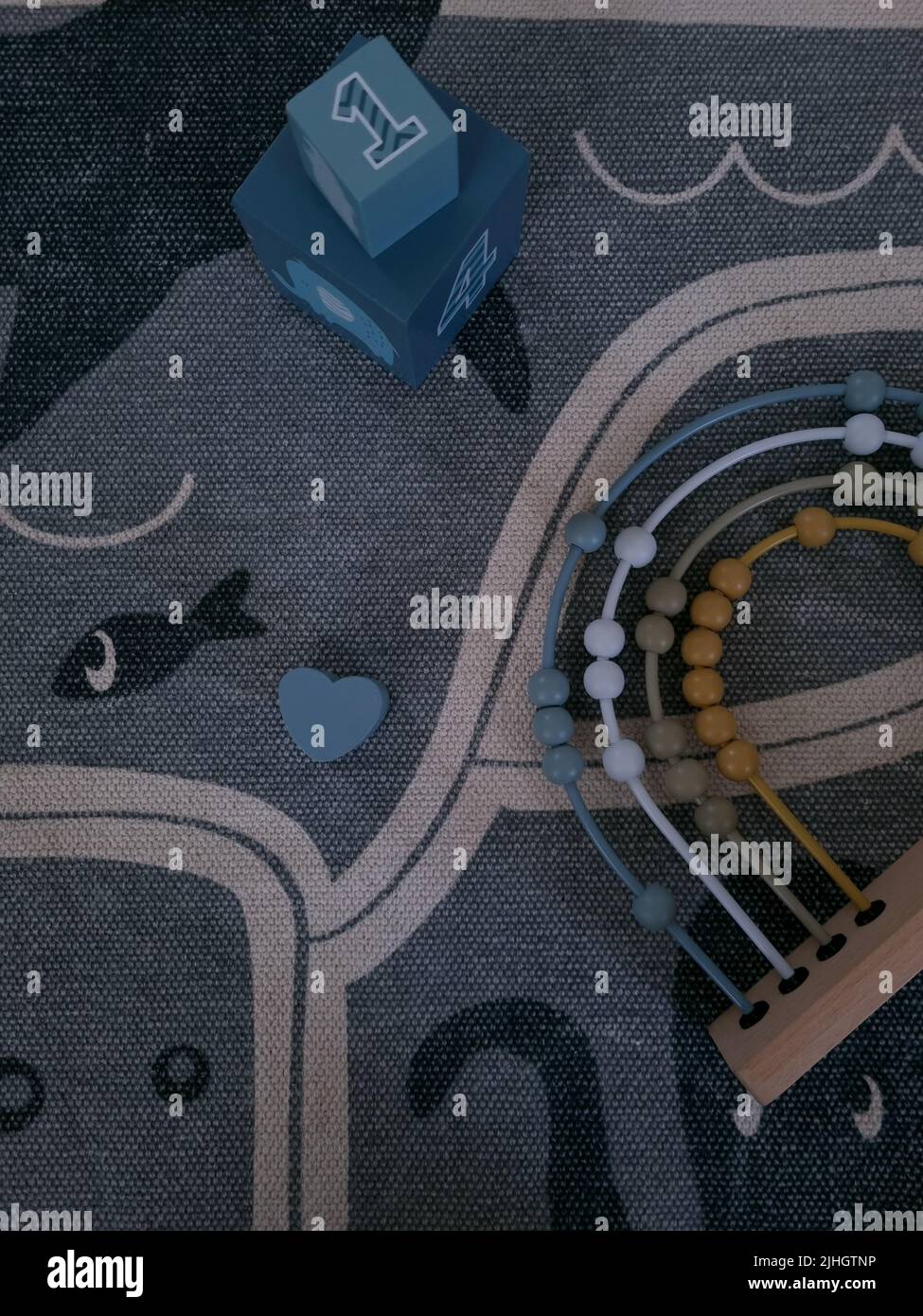 I bambini si bloccano e abacus su un tappeto. Giocattoli in legno moderni ed ecologici per un bambino. I giocattoli per l'istruzione si appoggiano su un tappeto. Imparare i numeri e contare. Foto Stock