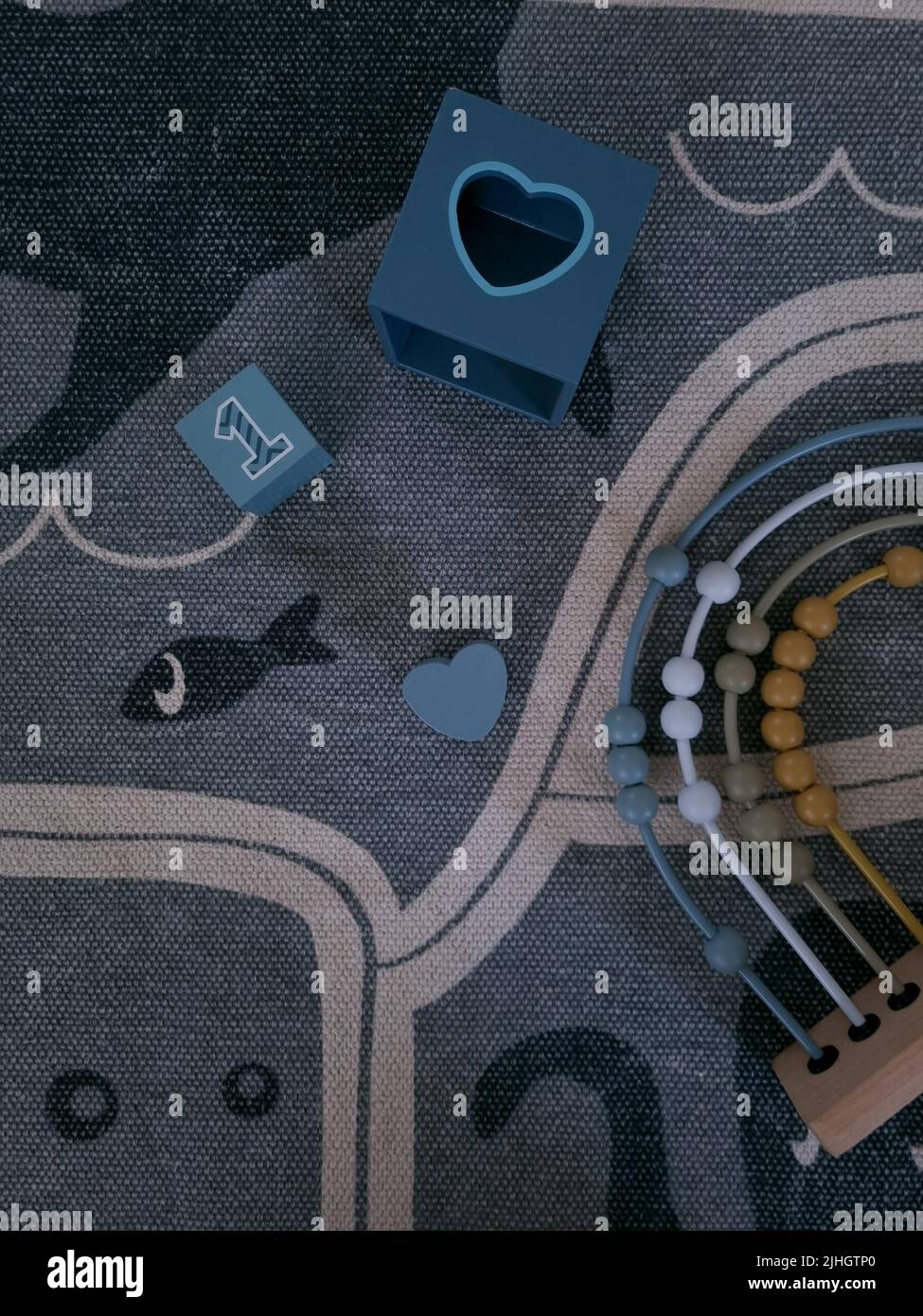 I bambini si bloccano e abacus su un tappeto. Giocattoli in legno moderni ed ecologici per un bambino. I giocattoli per l'istruzione si appoggiano su un tappeto. Imparare i numeri e contare. Foto Stock