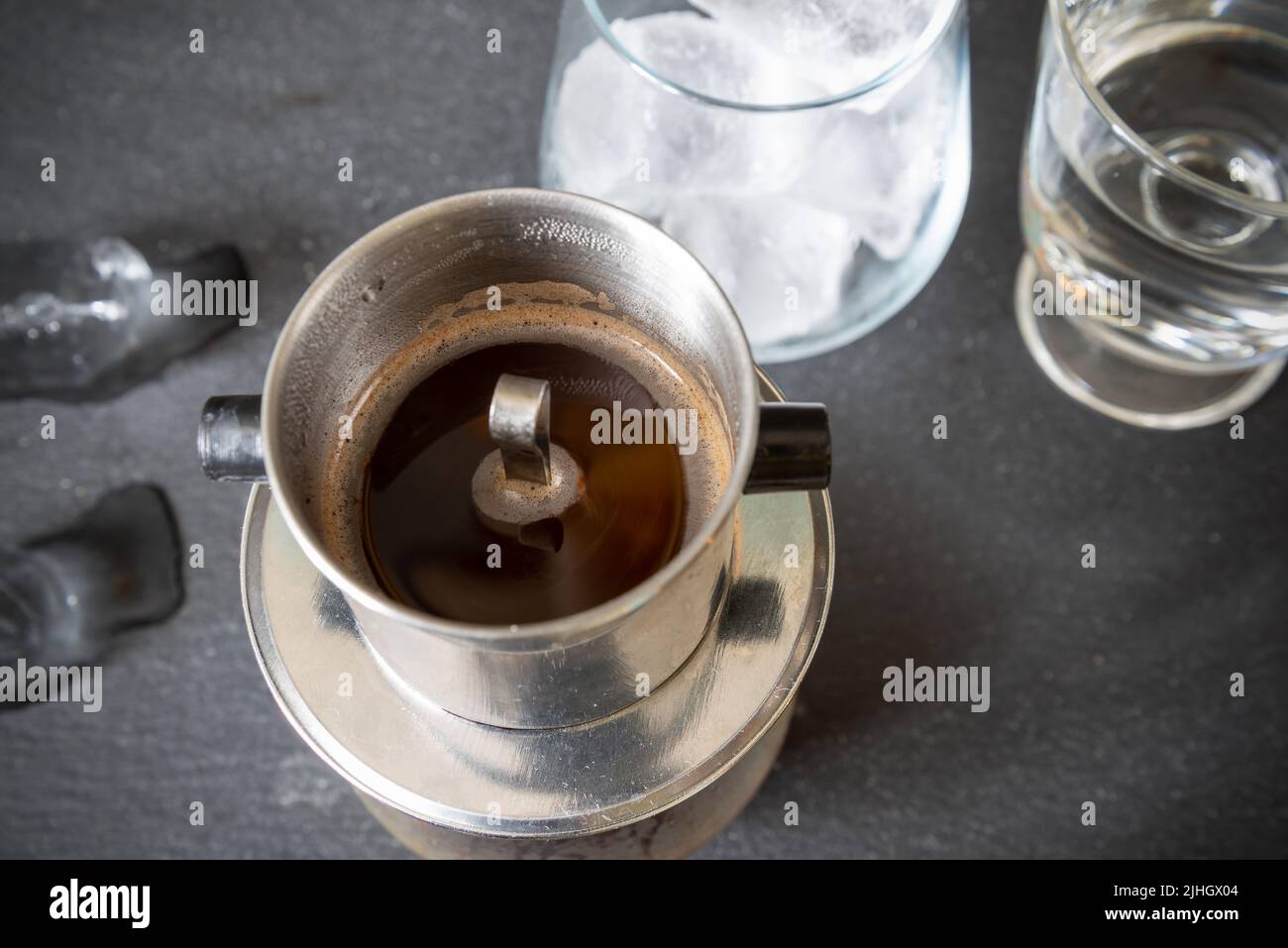 Un tradizionale modo vietnamita di preparare il caffè utilizzando un filtro speciale - phin. Caffè con latte condensato e ghiaccio. Vista dall'alto. Foto Stock