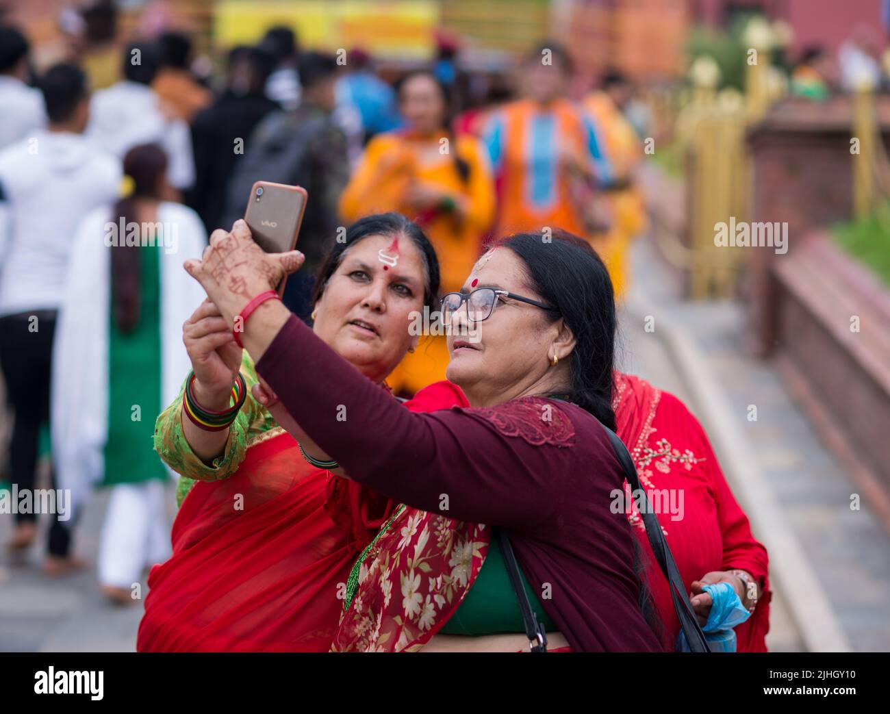 Kathmandu, Nepal. 18th luglio 2022. Le donne anziane prendono un selfie dopo aver visitato il tempio durante il festival di Shrawan Brata a Kathmandu. Durante il mese di Shrawan, ogni Lunedi le donne indù nepalesi adorano Lord Shiva per una lunga e prospera vita per il loro marito o per ottenere una buona. Credit: SOPA Images Limited/Alamy Live News Foto Stock