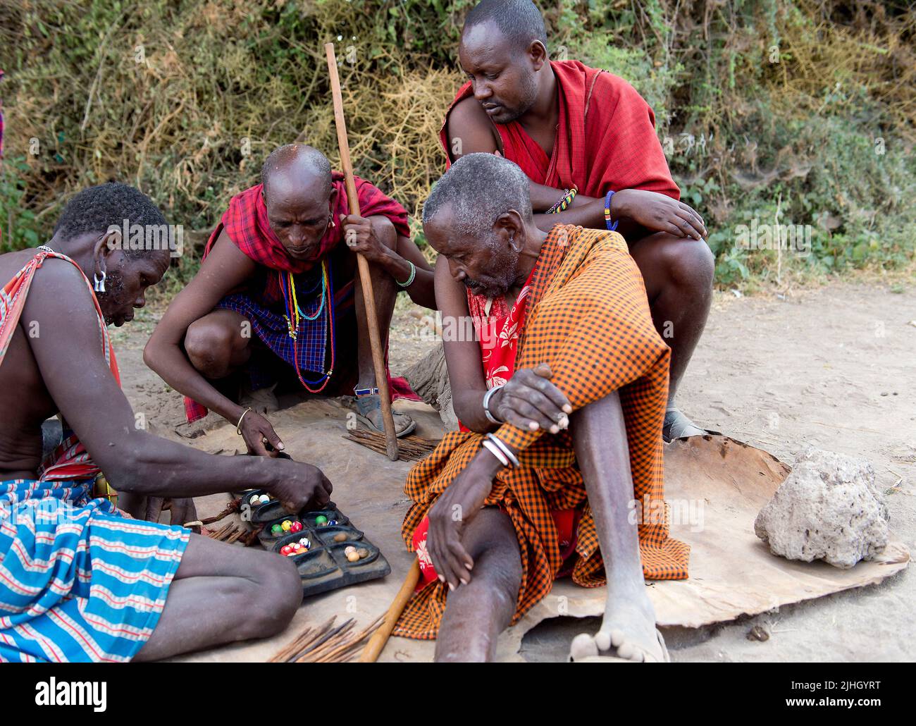 Anziani mambers di una tribù Masai da Amboseli, Kenya, giocare una partita locale noto come Bao. Foto Stock