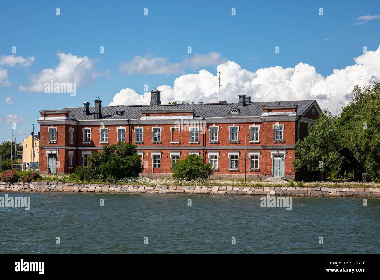 Edificio in mattoni rossi sul mare nell'isola Pikkku Mustasaari del distretto di Suomenlinna, Helsinki, Finlandia Foto Stock
