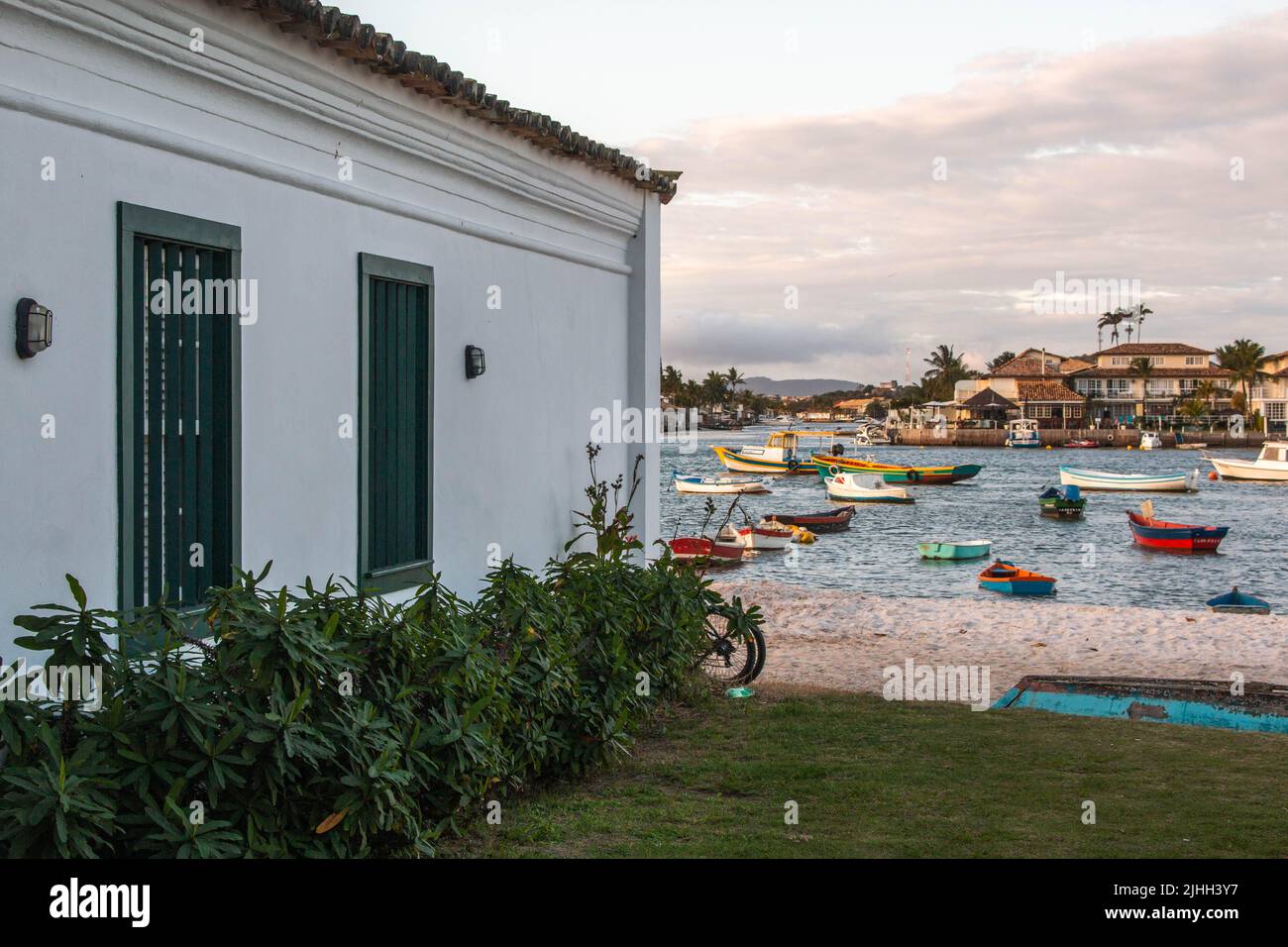 Tipica casa coloniale accanto alla spiaggia con piccole barche da pesca, nel quartiere Passage, Cabo Frio, Brasile. Foto Stock