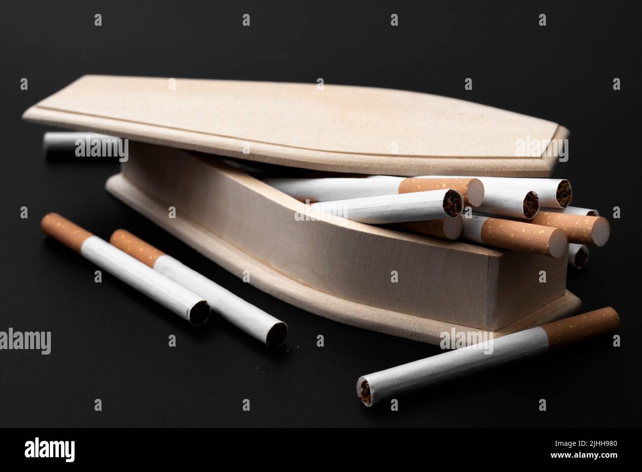 Moody immagine di vera bara di legno riempito di sigarette nel concetto di oscurità per smettere di fumare per prevenire la morte, cancro ai polmoni consapevolezza e sigarette kil Foto Stock