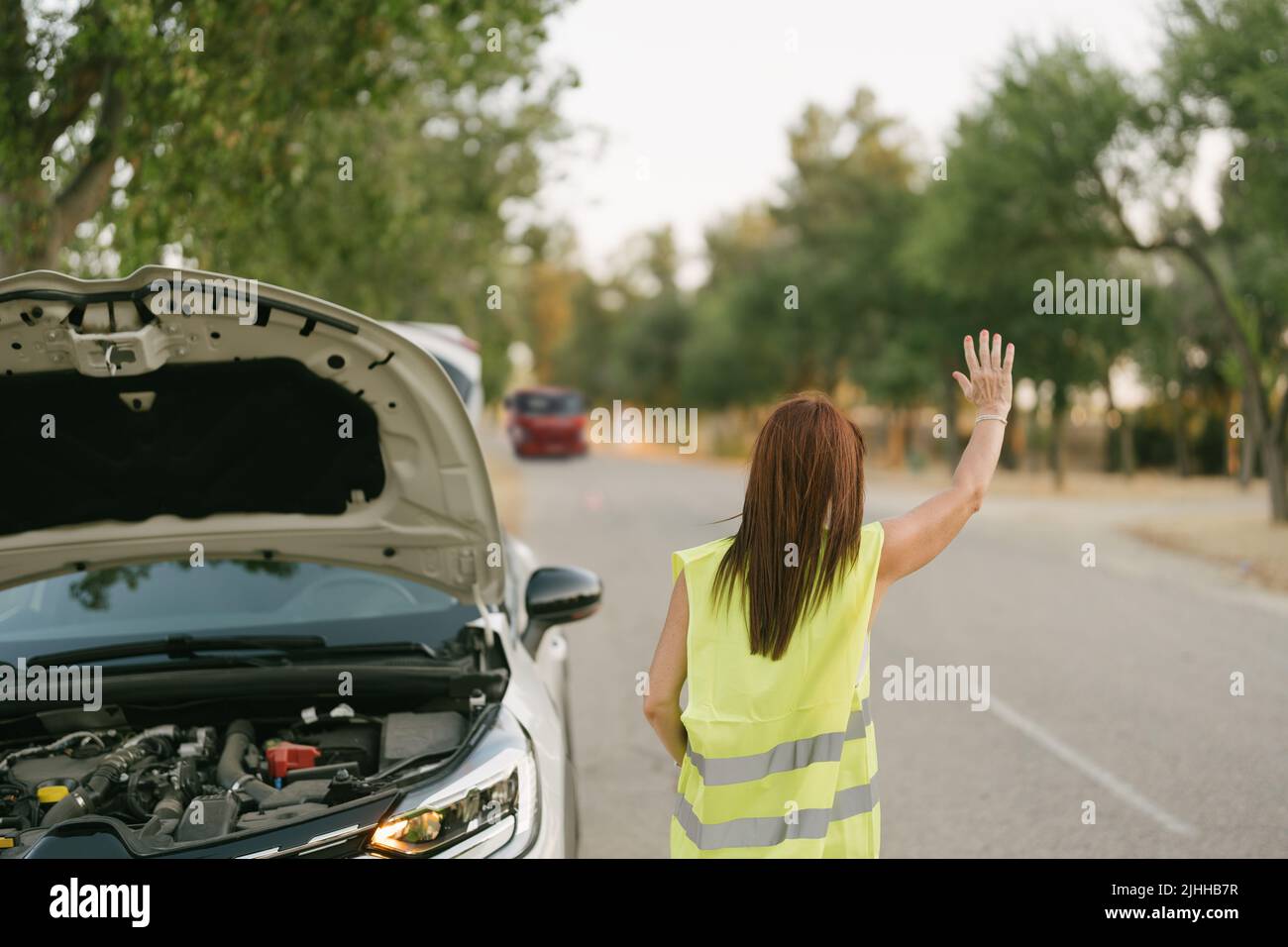 donna con mano sollevata che segnala il carrello di traino Foto Stock