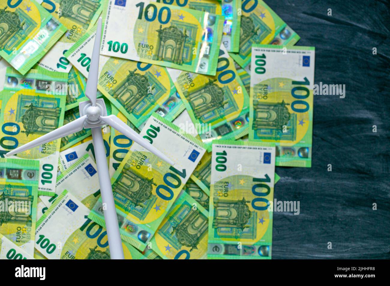 costo dell'energia rinnovabile. Pagamento per energia eolica. Costo di energia rinnovabile verde. Generatore di vento bianco su euro verde fatture background.alternative Foto Stock