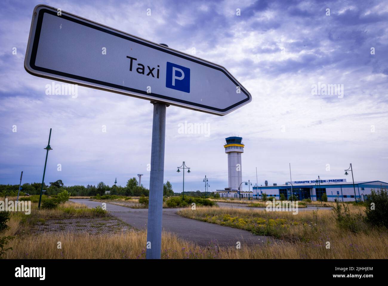 Parchim, Germania. 18th luglio 2022. Un cartello per i taxi si trova nello spazioso parcheggio di fronte all'edificio del terminal dell'ex aeroporto. Dopo essere stato acquistato da un investitore cinese, l'ex aeroporto militare dell'esercito russo doveva essere sviluppato in un centro di volo internazionale del carico. Dopo l'insolvenza dell'operatore nel maggio 2019, le operazioni di volo sono cessate e gli impianti all'aperto sono parzialmente sopravallevati. Credit: Jens Büttner/dpa/Alamy Live News Foto Stock