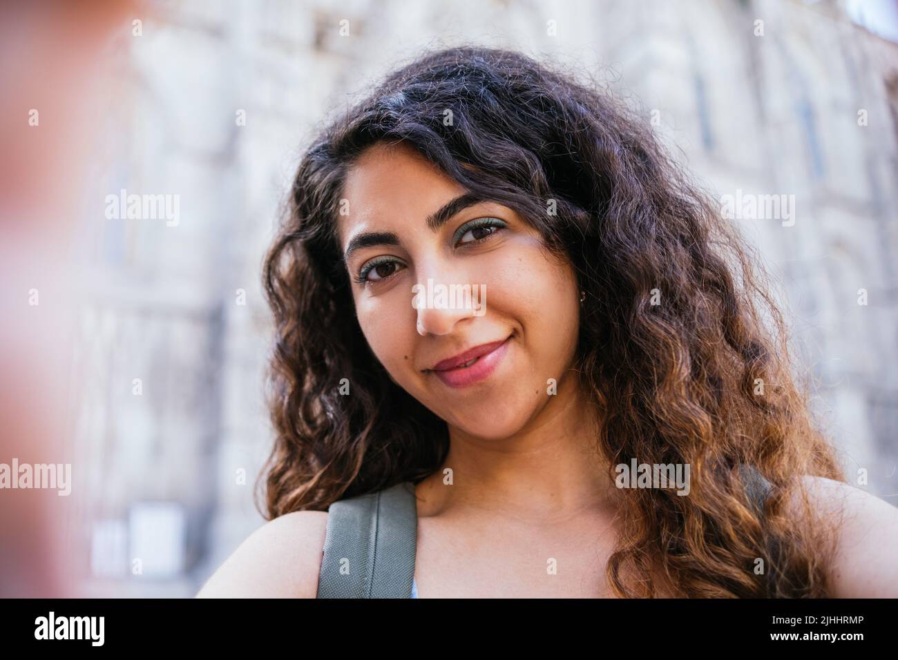 Autoritratto con telefono di una giovane donna indiana attraente guardando la macchina fotografica per le strade Foto Stock