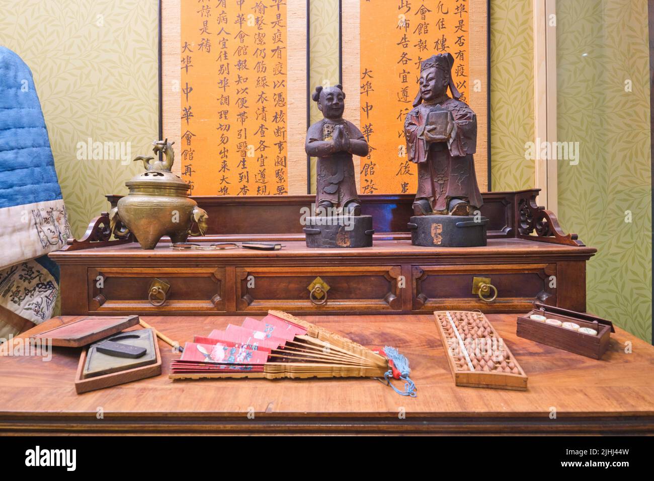 Una mostra di un tipico banco di legno immigrato cinese con figure, ventilatore, abaco e altri oggetti asiatici. All'Oakland Museum of Art di Oakland, California Foto Stock