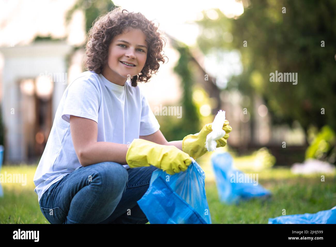 Teen ricci-pelo raccolta rifiuti nel parco Foto Stock