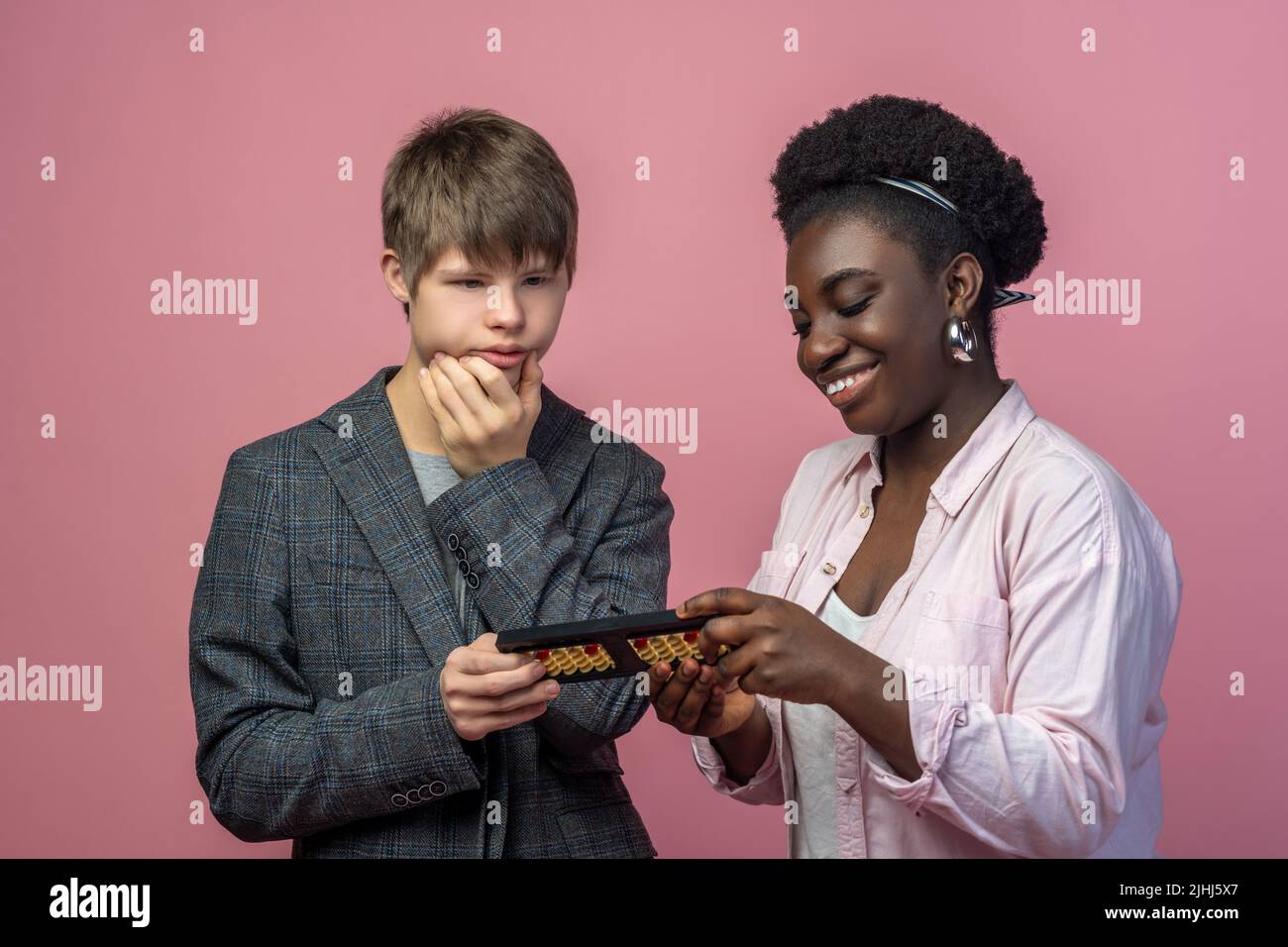 Ragazzo pensante e insegnante sorridente con abaco Foto Stock