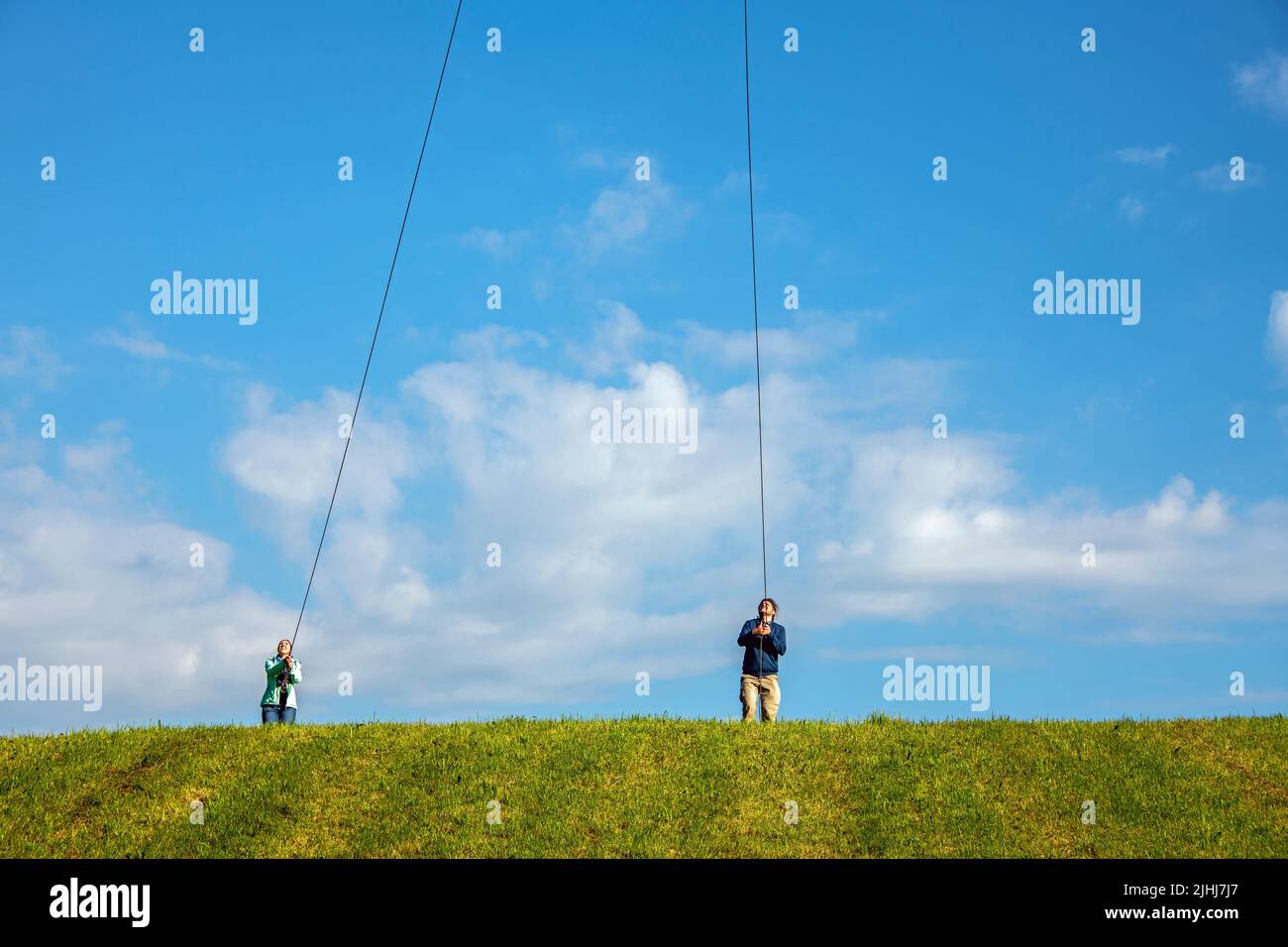 Persone che fanno sforzi per trascinare corde per tenere qualcosa dal cielo alla terra Foto Stock