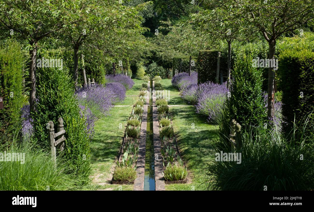 Giardino paesaggistico con lavanda e acqua corrente a Jardin Domaine de Poulaines nella Valle della Loira, Francia. Foto Stock