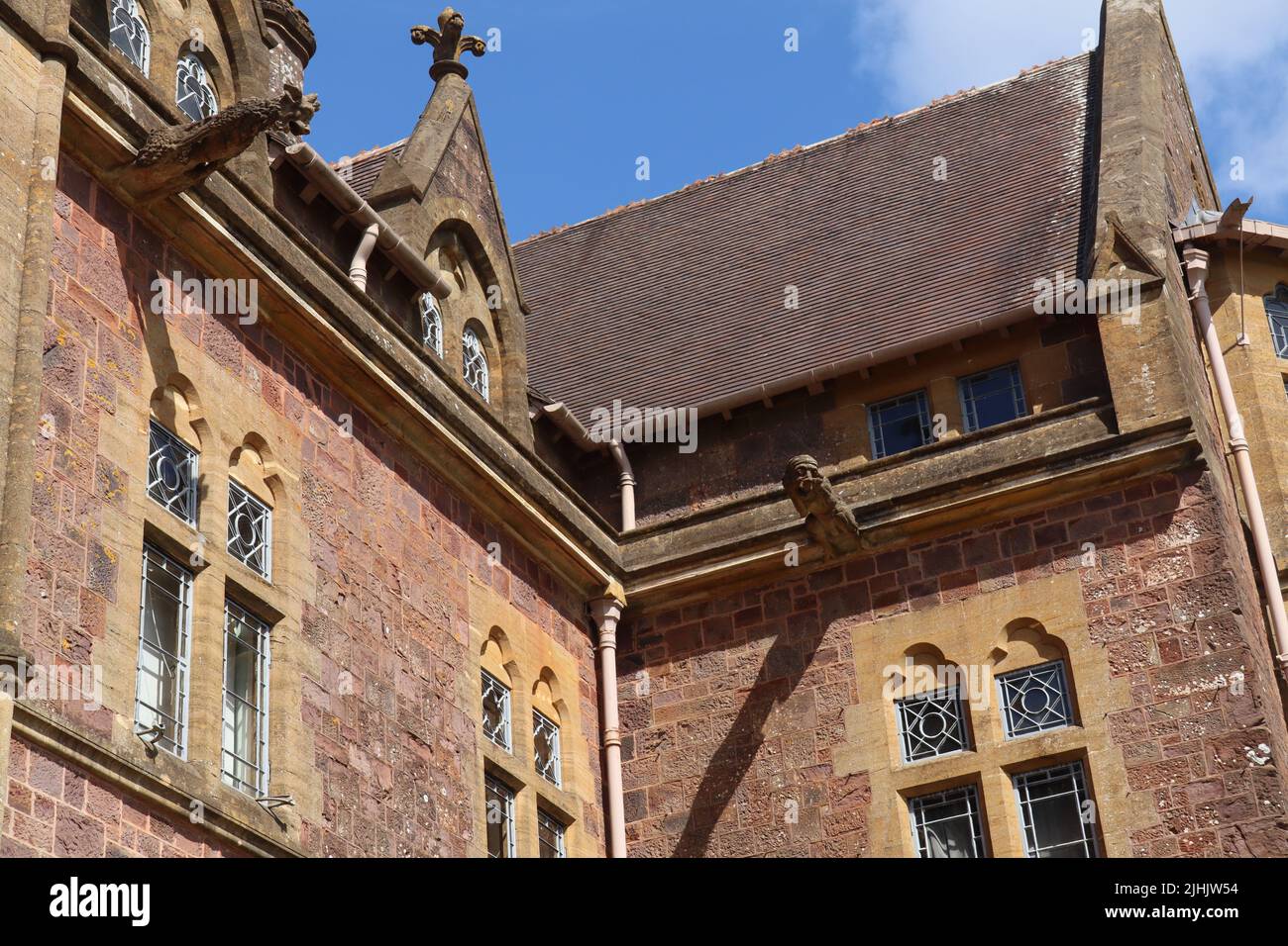 Guardando in su a due gargoyles su una casa di campagna inglese Foto Stock
