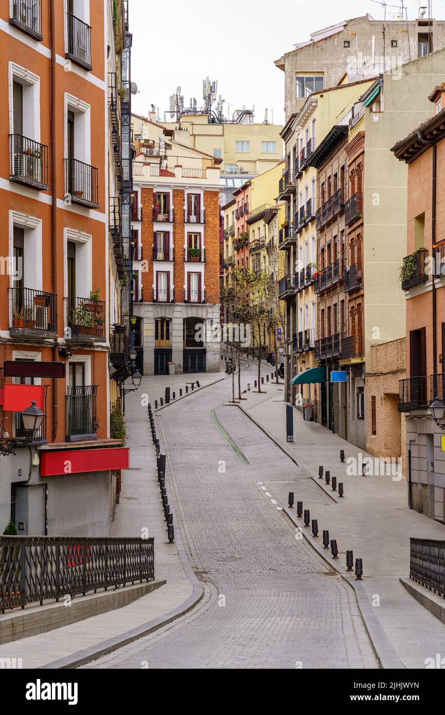 Tipica strada di Madrid che si snoda tra edifici con finestre e balconi tipici della città. Spagna. Foto Stock