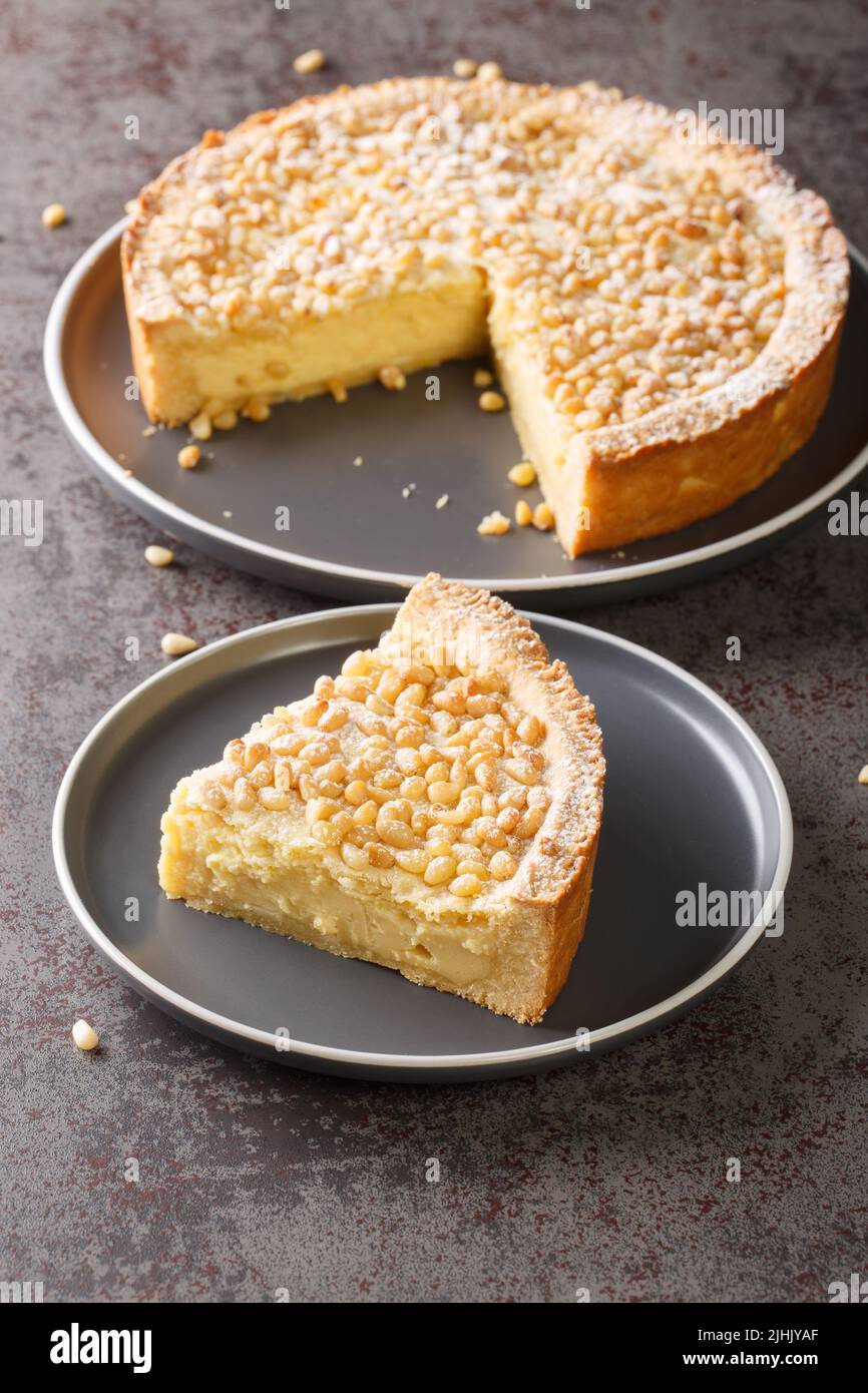 Torta crema pasticcera con pinoli torta della nonna o torta della nonna primo piano nel piatto sul tavolo. Verticale Foto Stock