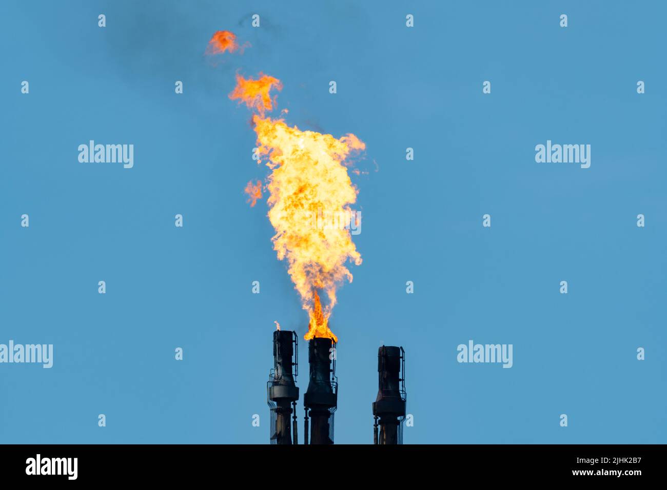 Gas di flare in raffineria di petrolio, catasta di flare che brucia il gas in eccesso. Fiamma di raffineria di petrolio, fiocchi, flaring, camino, inquinamento, prodotti petrolchimici, ciminiera. REGNO UNITO Foto Stock