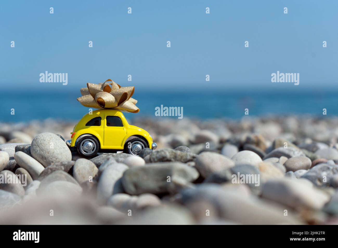 Un'auto gialla con un arco in cima in piedi sul mare Foto Stock