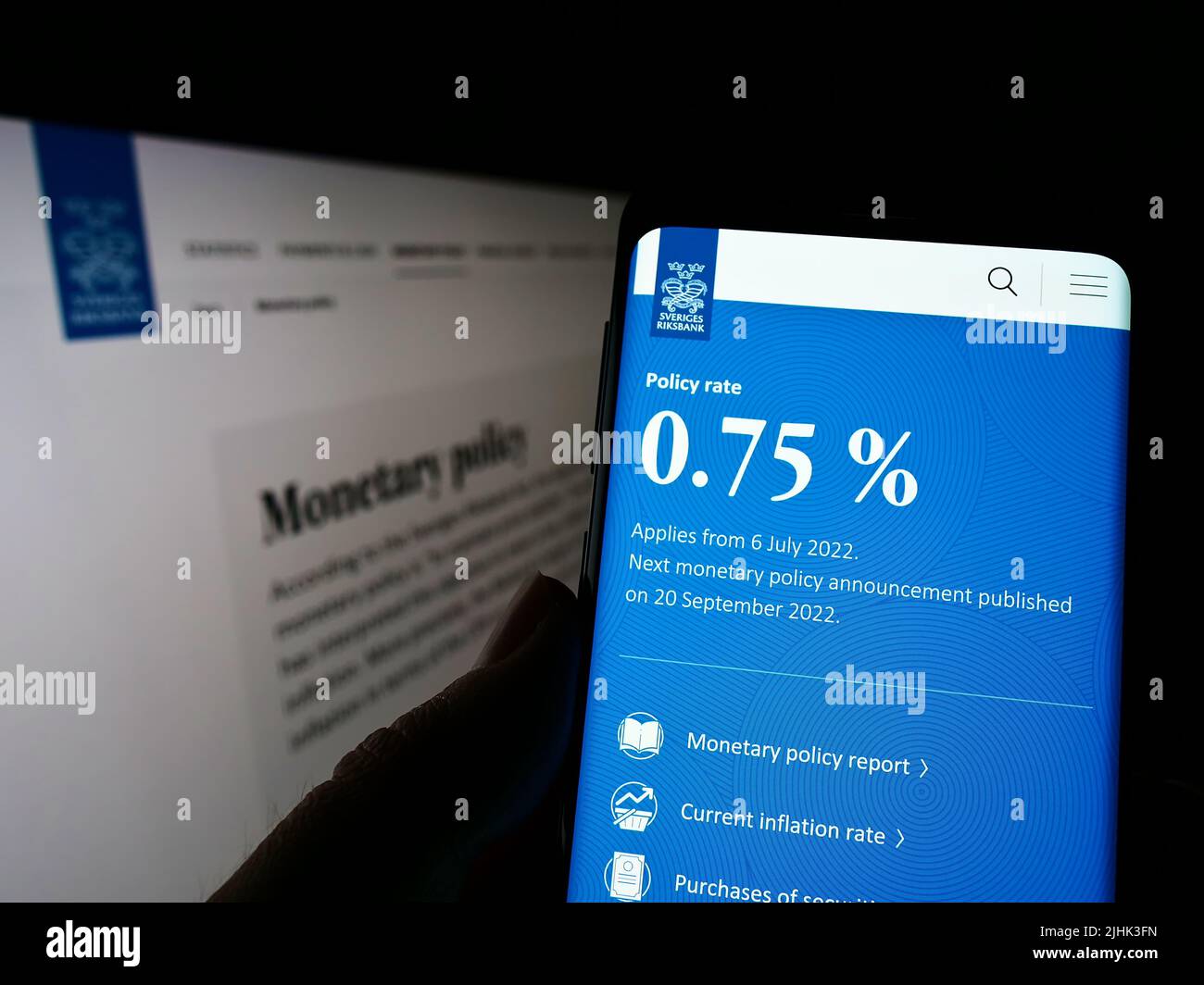 Persona che detiene il cellulare con il sito web e il logo della banca centrale svedese Sveriges Riksbank sullo schermo. Concentrarsi sul centro del display del telefono. Foto Stock