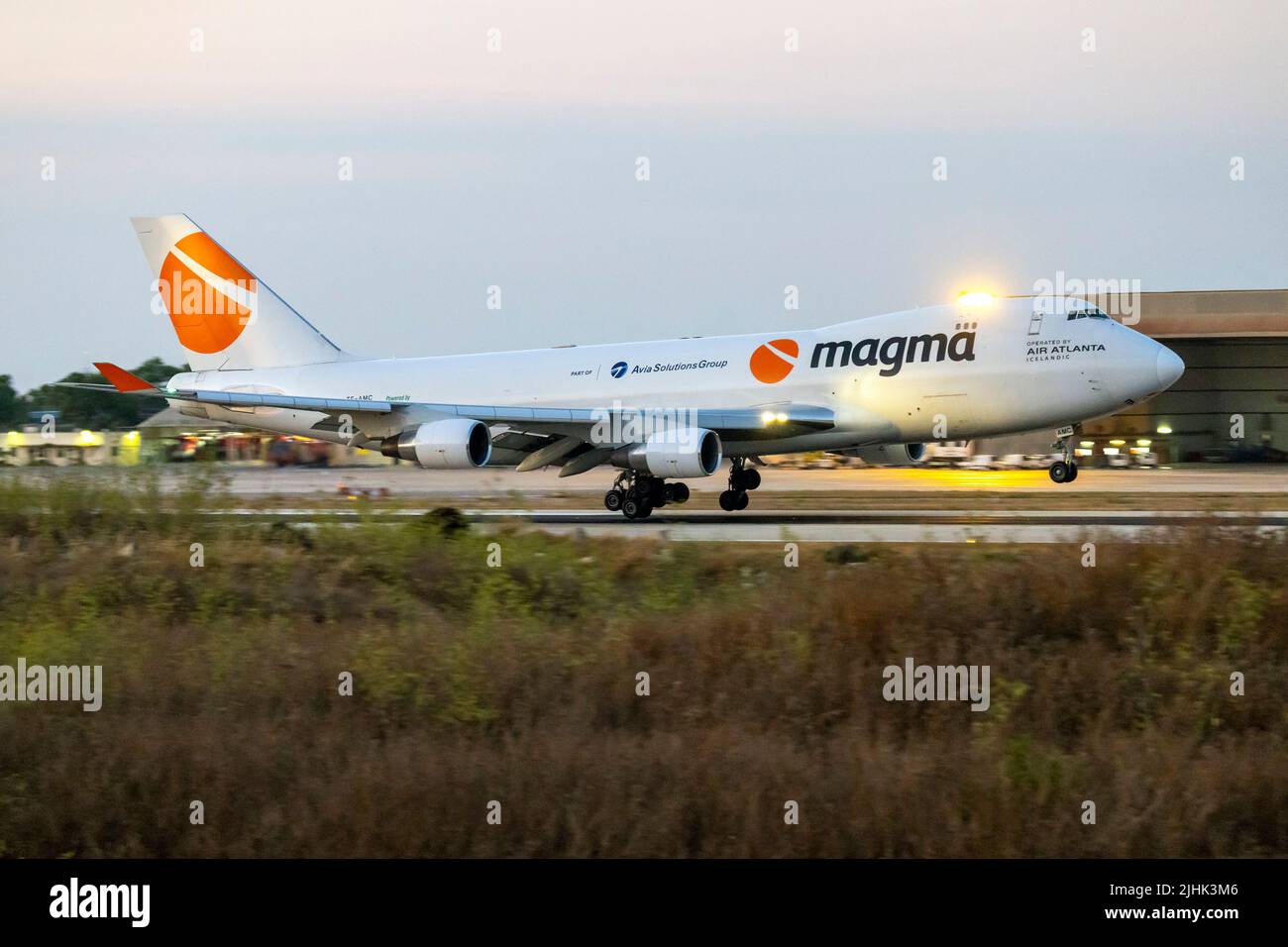 Magma (Air Atlanta Icelandic) Boeing 747-412F-SCD (REG: TF-AMC) arrivando dopo che il sole è tramontato sull'orizzonte. Foto Stock