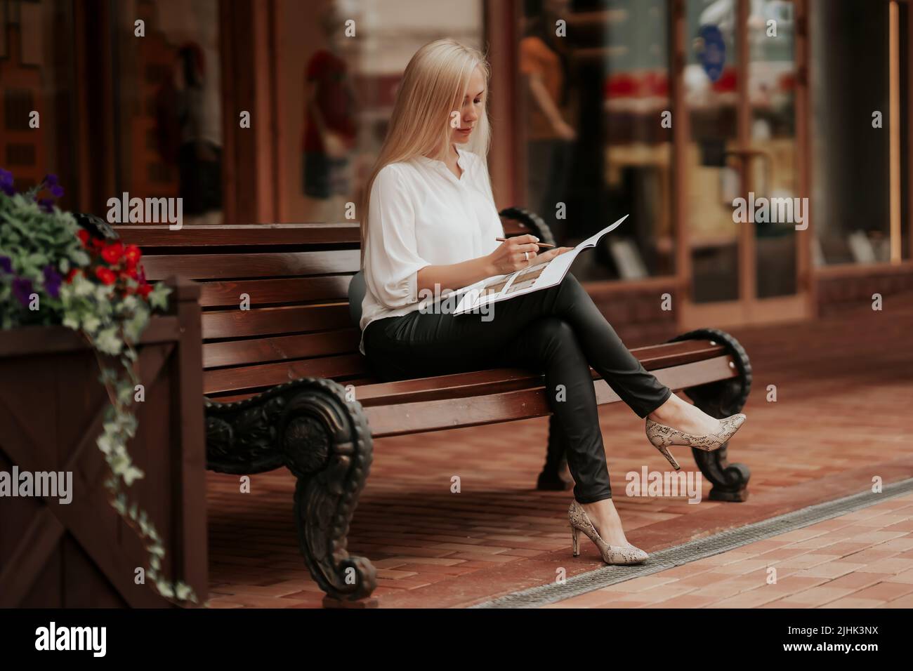 Una donna d'affari sicura seduta sul banco di lavoro sul progetto Foto Stock